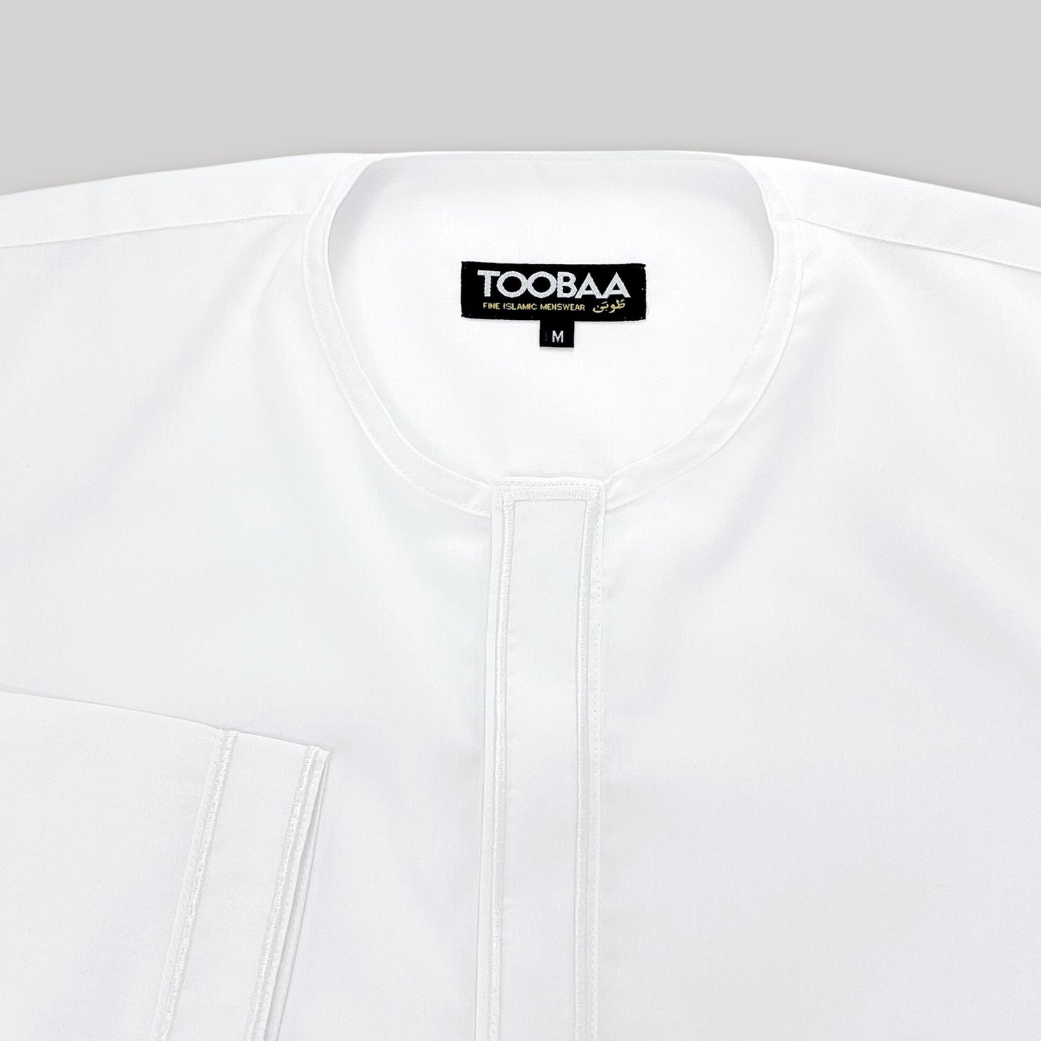 Close-up of the round neck detail, immaculate stitching and embroidery of Toobaa's white jubah Ihsan.