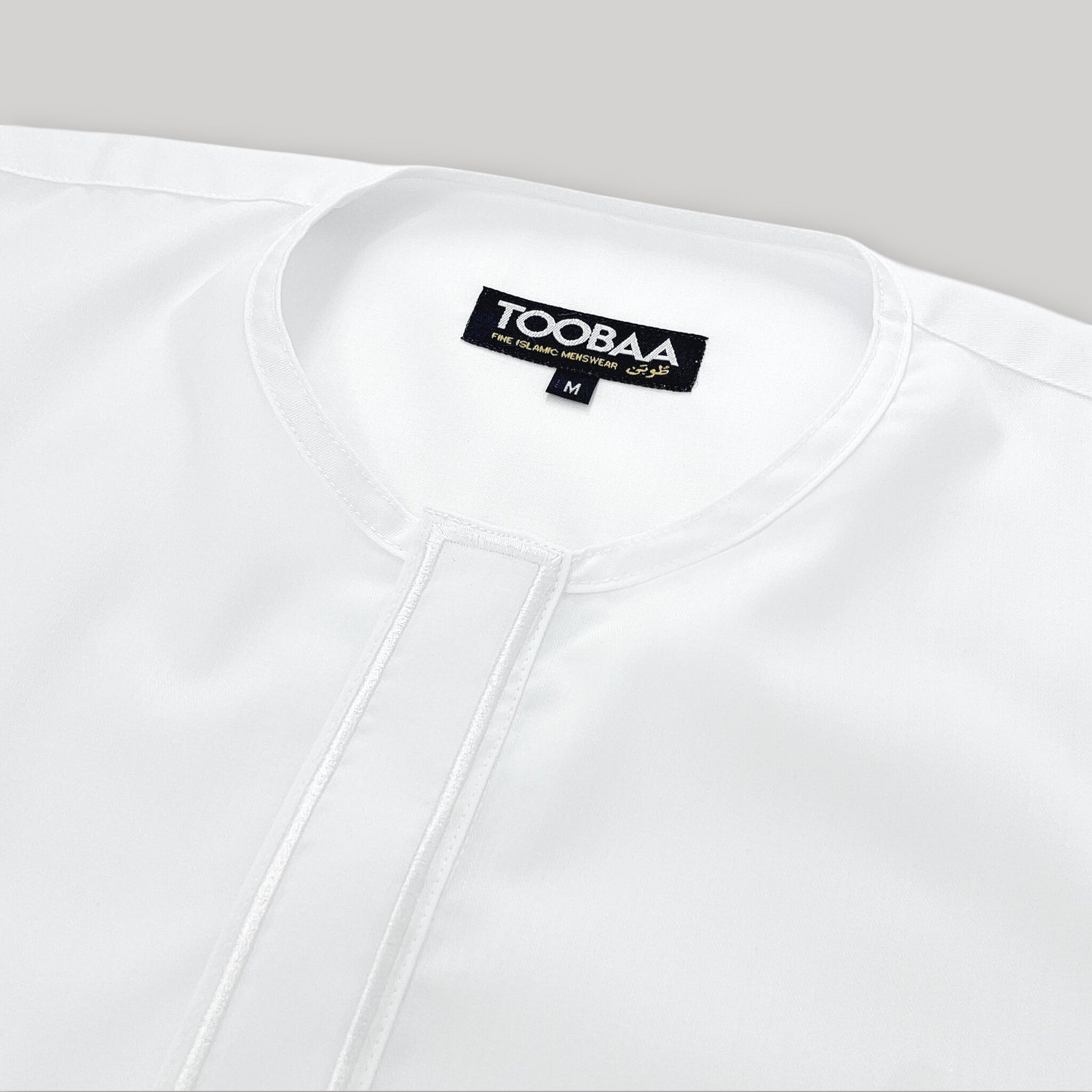 Close-up flat-lay view of Toobaa's pristine white men's thobe - Jubah Ihsan